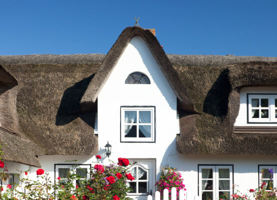 Fenêtre en arc sur maison en chaume