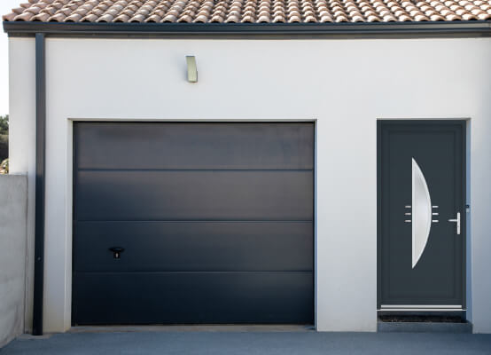 Porte de service Vincennes anthracite sur façade extérieure de la maison