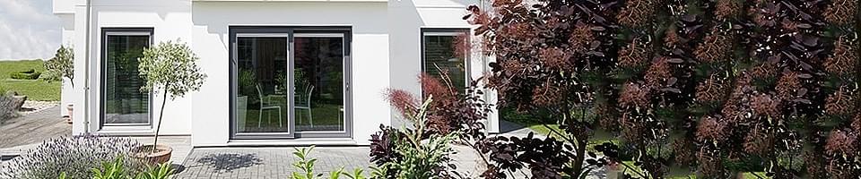 Maison avec jardin et terrasse avec porte-fenêtre double sortant de la salle à manger
